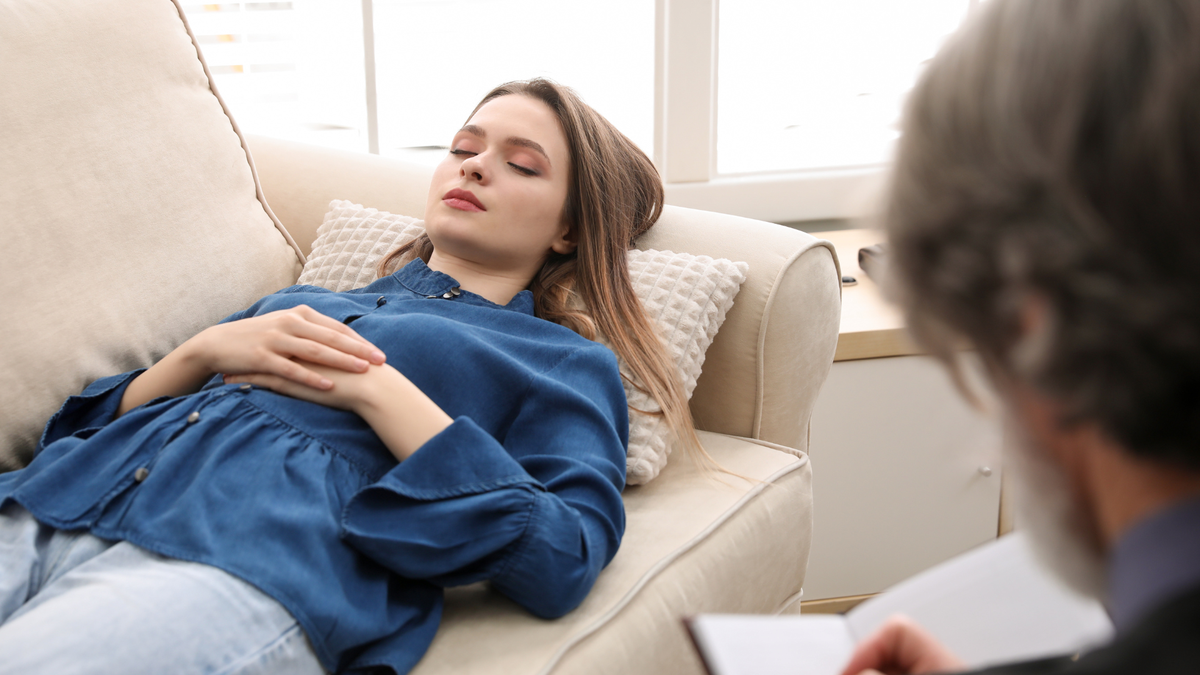 Woman resting on couch during ketamine-assisted psychotherapy session and therapeutic integration.